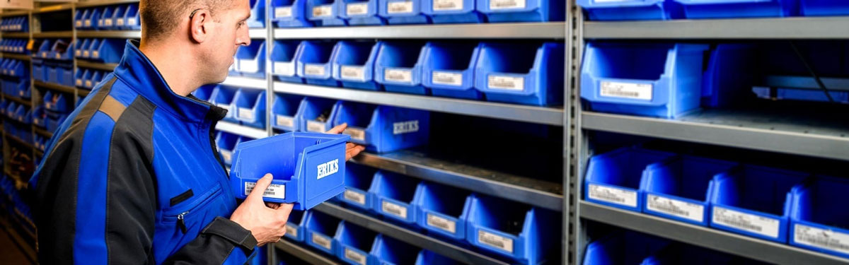 ERIKS Mitarbeiter sortiert Kanban-Behälter in ein Regal